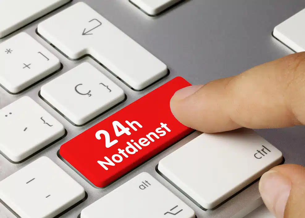 Auf diesem Bild ist eine Notdienstbutton auf einer Tastatur zu sehen und ein Finger zeigt drauf.